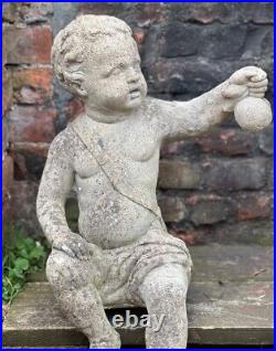 PAIR 20th CENTURY CAST PUTTI HOLDING FRUIT IDEAL FOR BOTH SITTING ON A WALL