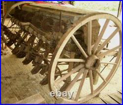 Two vintage 1920s large 4ft 5 inches tall wood wagon wheels on Smyth seed drill